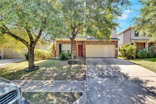 a front view of a house with a yard and trees