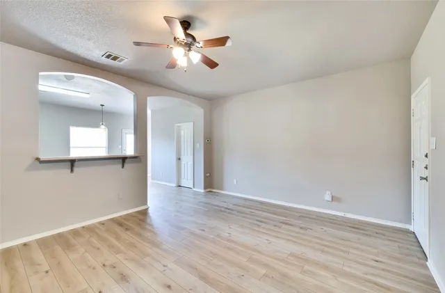 a view of an empty room with wooden floor