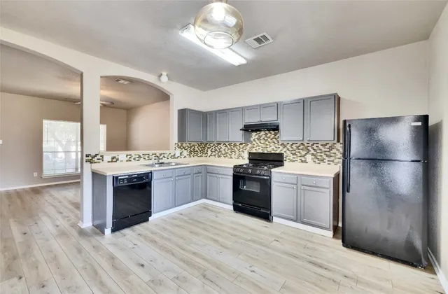 a kitchen with a refrigerator and a stove top oven