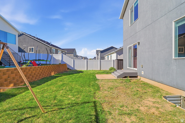 1177 South Raintree Lane Santaquin, UT 84655 - Photo 25 of 25 Fenced backyard featuring a retaining wall, a concrete patio, and a sliding glass door