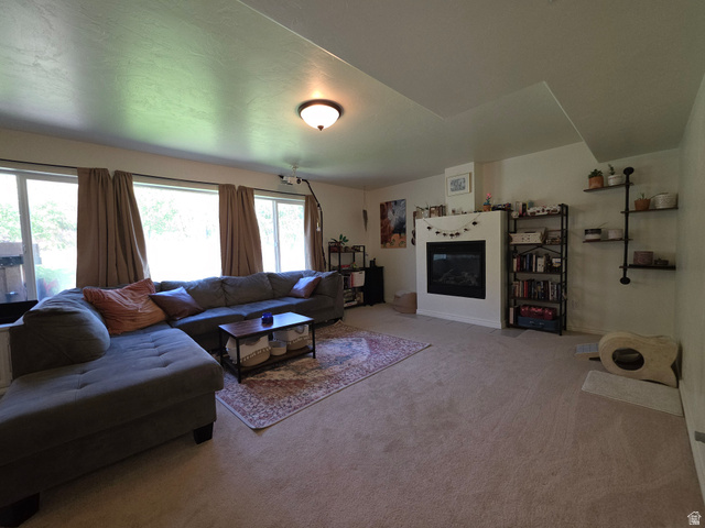 387 North Loafer Canyon Road Payson, UT 84651 - Photo 51 of 94 Spacious living area featuring ample natural light from multiple windows, a built-in fireplace, recessed ceiling, and carpeted flooring