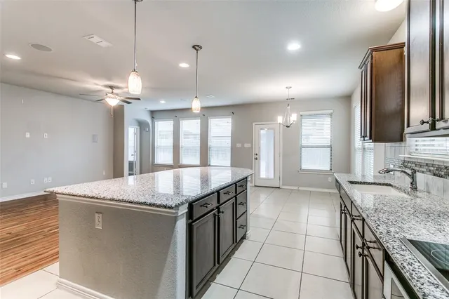 a kitchen with granite countertop a sink a counter top space appliances and cabinets