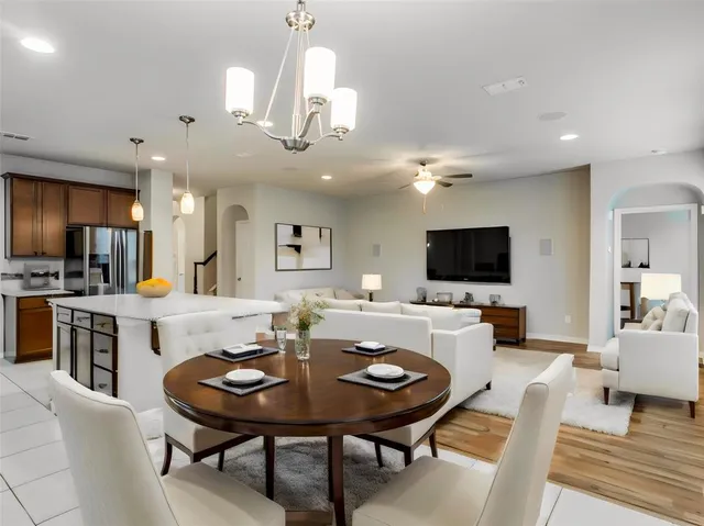 a view of a dining room with furniture a rug and wooden floor