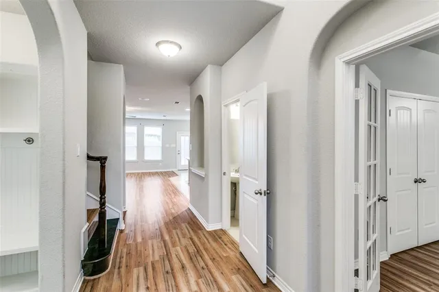 a view of a hallway with wooden floor and closet area
