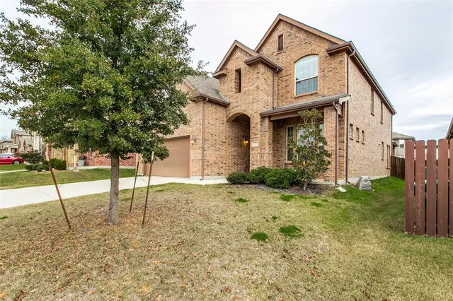 a view of a house with large windows and plants