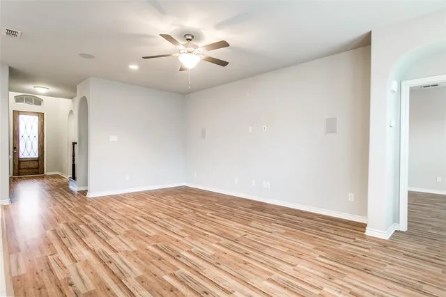 wooden floor in an empty room with a chandelier