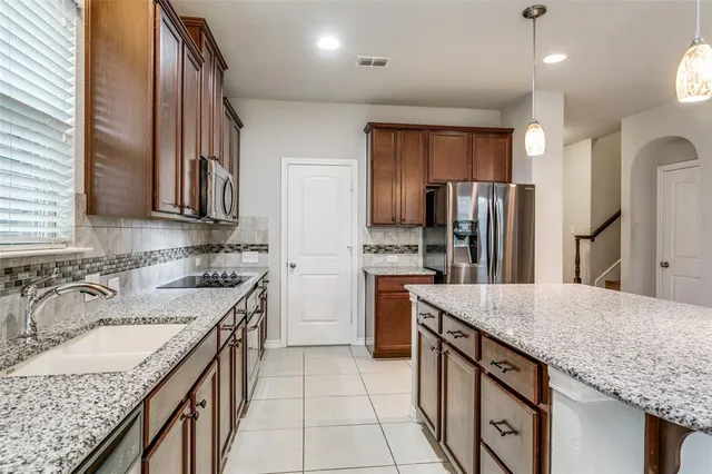 a kitchen with stainless steel appliances granite countertop a sink stove and refrigerator