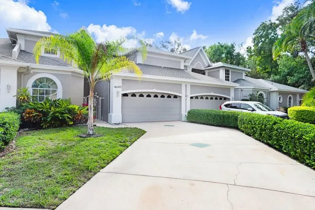 a front view of a house with a yard and potted plants