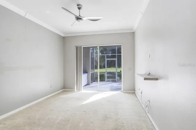 a view of a white house next to a yard with big trees