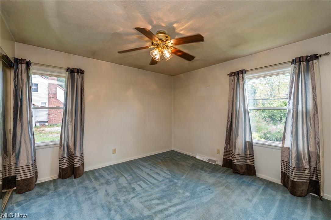 14179 Drake Road Strongsville, OH 44136 - Photo 17 of 33 Unfurnished room featuring ceiling fan, dark colored carpet, and plenty of natural light