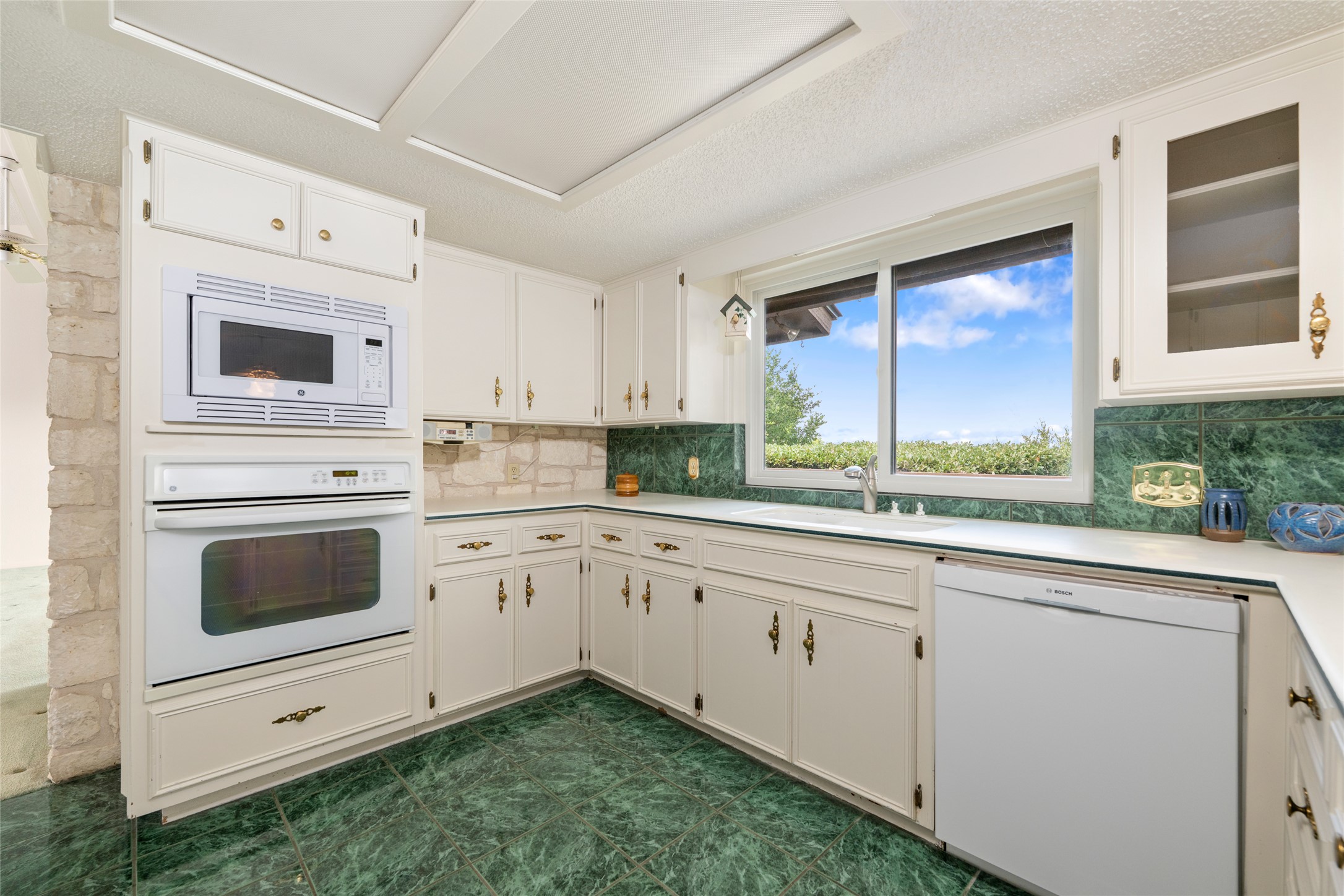 5319 Musket Ridge Austin, TX 78759 - Photo 16 of 39 Bright white cabinetry and verdant backsplash create a dynamic, functional kitchen space.