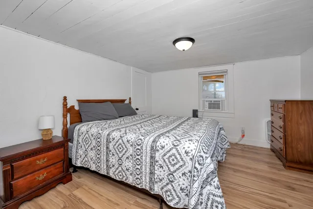 a bedroom with bed and wooden floor