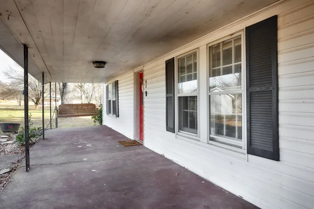 a view of a porch with a floor to ceiling window and wooden floor