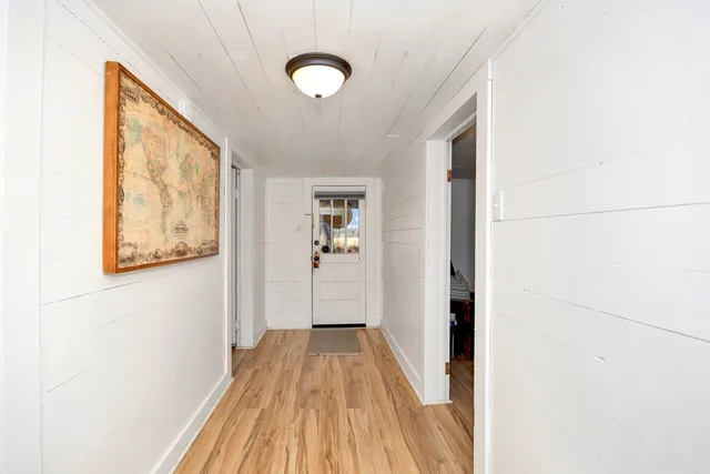 a view of a hallway with wooden floor