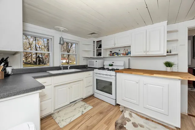 a kitchen with granite countertop white cabinets and white appliances