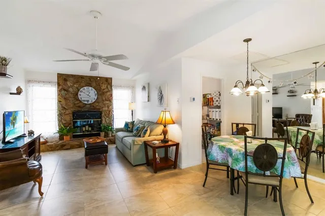 a living room with furniture a chandelier and a fireplace