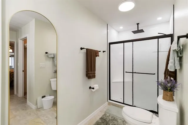 a bathroom with a granite countertop sink a toilet and a mirror