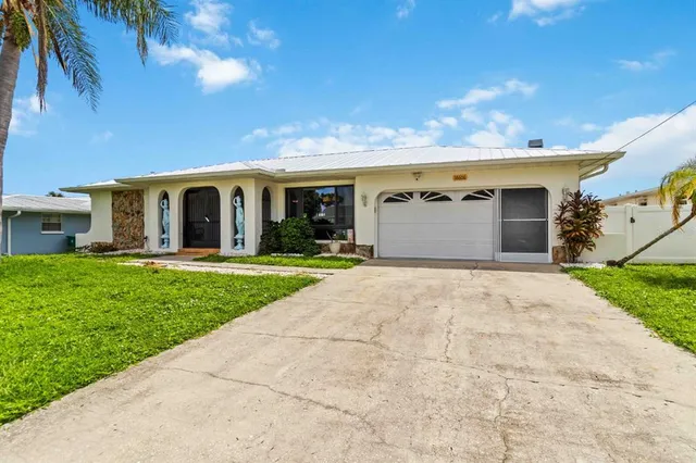 a view of a white house with a yard and potted plants