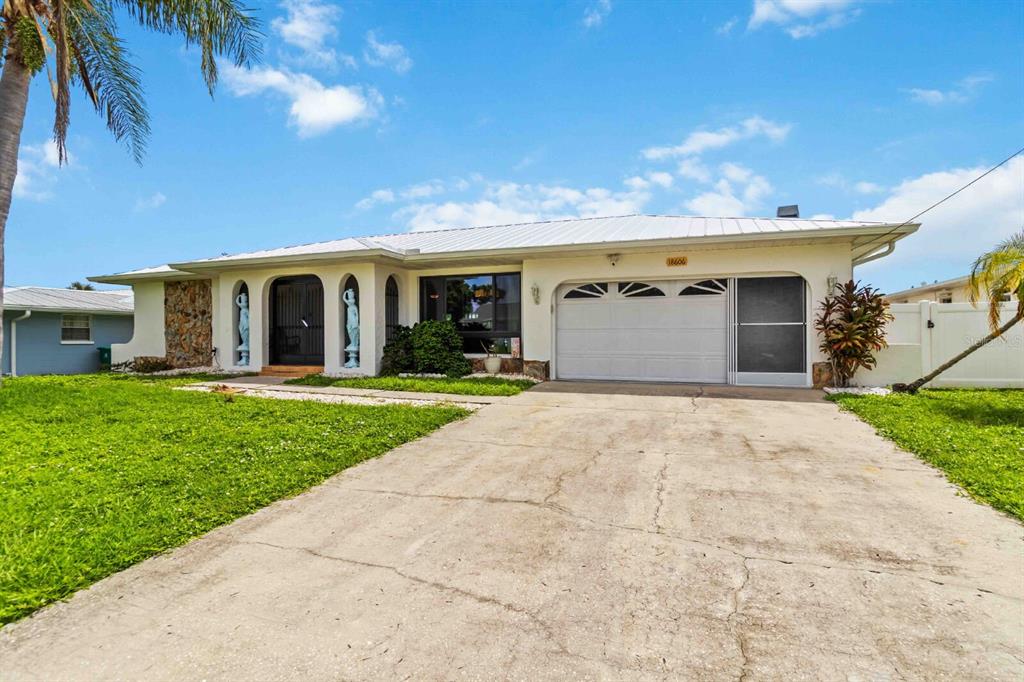 18606 Briggs Circle Port Charlotte, FL 33948 - Photo 2 of 44 a view of a white house with a yard and potted plants