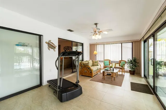 a living room with furniture gym equipment and a large window