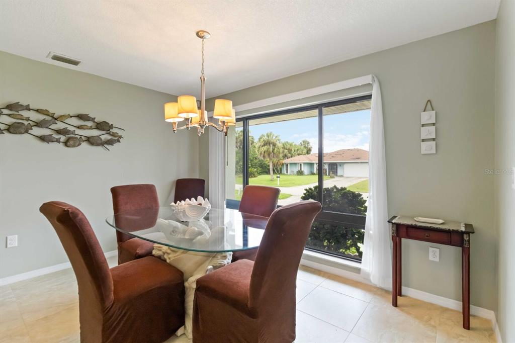 18606 Briggs Circle Port Charlotte, FL 33948 - Photo 8 of 44 a dining room with furniture a chandelier and window