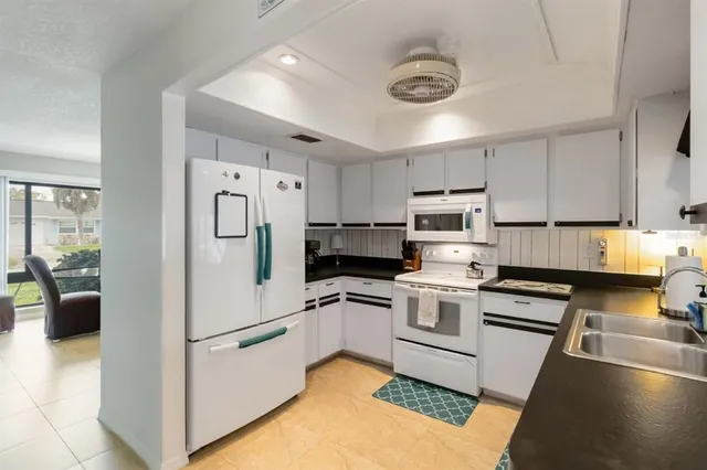 a kitchen with granite countertop a refrigerator stove and sink