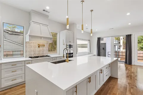 a large kitchen with kitchen island a large island a sink stainless steel appliances and cabinets