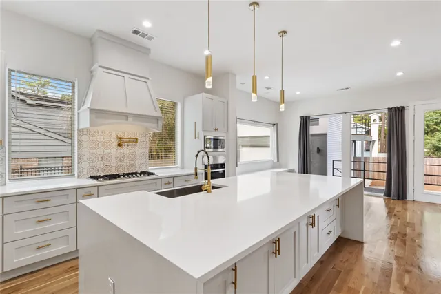 a large kitchen with kitchen island a large island a sink stainless steel appliances and cabinets