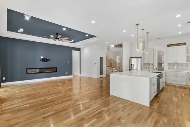a large white kitchen with kitchen island a sink a stove and a refrigerator