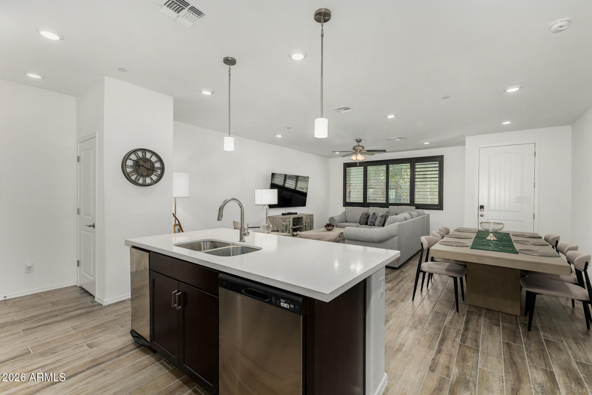 1917 East Hampton Lane, Unit 104 Gilbert, AZ 85295 - Photo 7 of 39 a room with stainless steel appliances kitchen island a white table chairs and a wooden floor