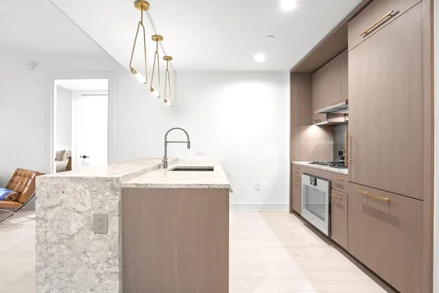 a kitchen with kitchen island sink stove and refrigerator