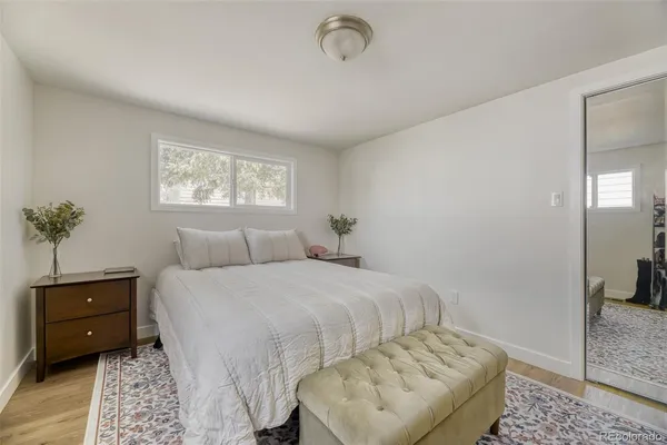 a bedroom with a bed a couch and potted plant