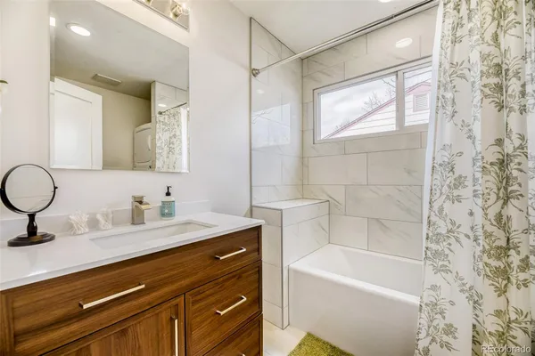 a bathroom with a tub sink and mirror