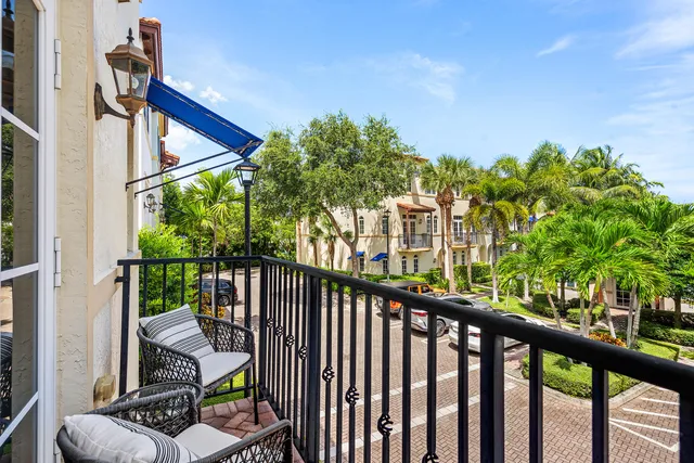 a view of a balcony with floor to ceiling windows and wooden fence