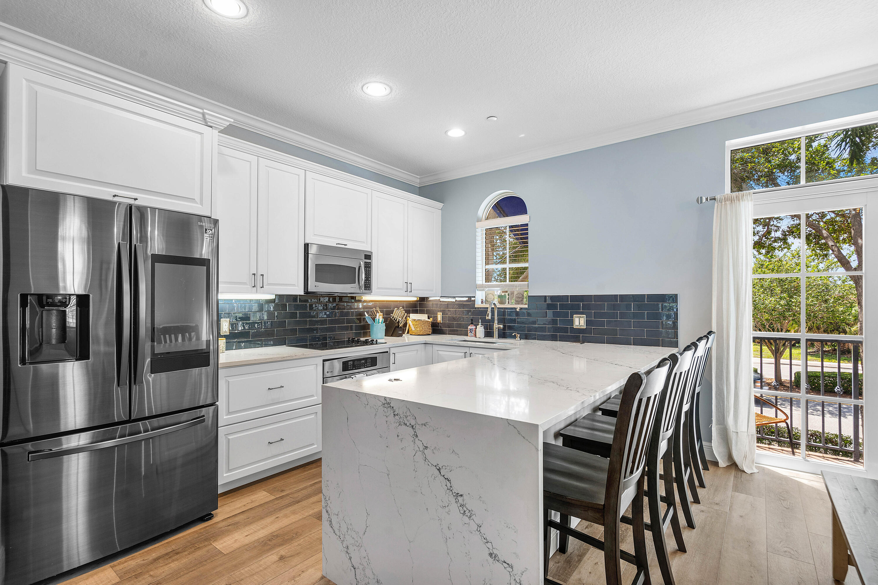 3261 Estancia Way Boynton Beach, FL 33435 - Photo 17 of 51 a kitchen with stainless steel appliances granite countertop a stove a refrigerator a sink a stove and white cabinets with wooden floor