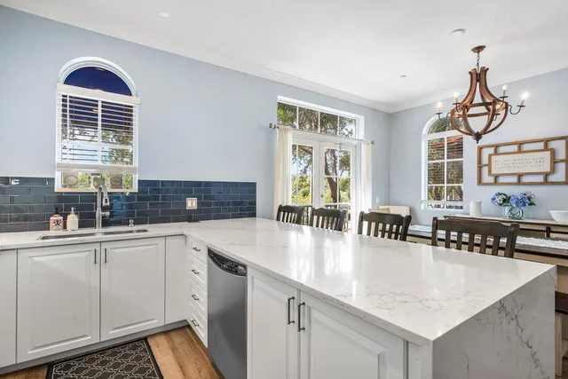 a kitchen with stainless steel appliances granite countertop a sink a stove and cabinets