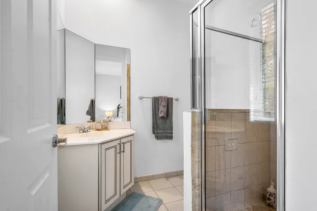 a bathroom with a granite countertop sink a shower and a mirror