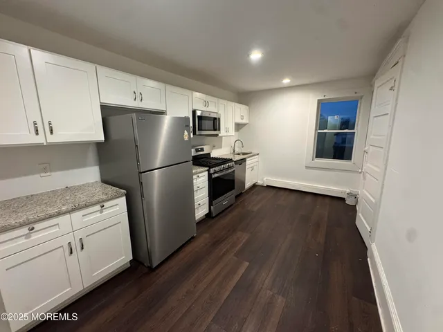 a kitchen with a refrigerator and a stove top oven