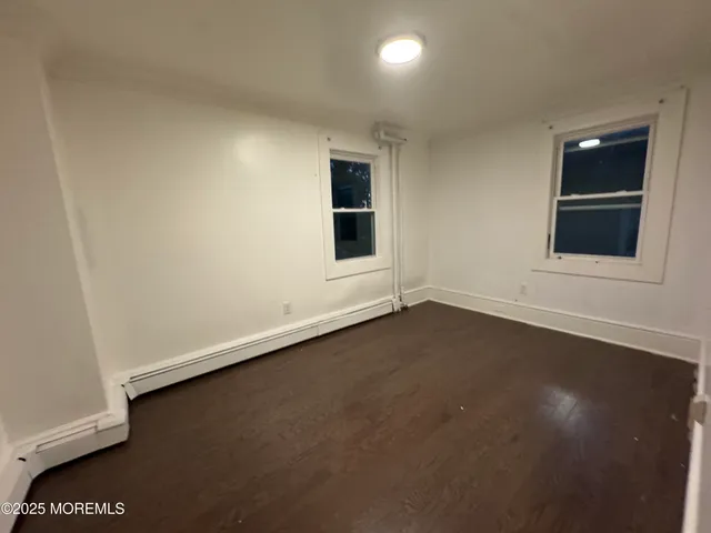 an empty room with a window and wooden floor