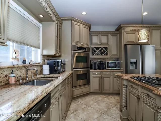 a kitchen with stainless steel appliances granite countertop a stove refrigerator and cabinets