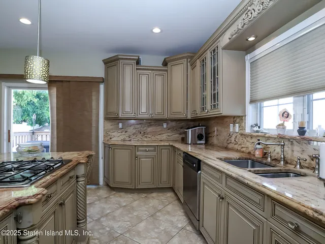 a kitchen with kitchen island granite countertop a sink stove and cabinets