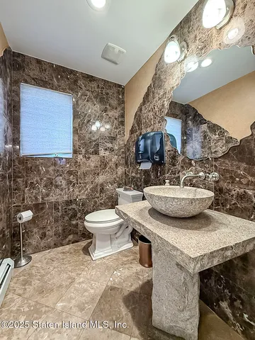 a bathroom with a sink a toilet and mirror