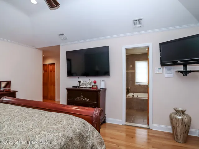 a bedroom with a bed and a flat screen television