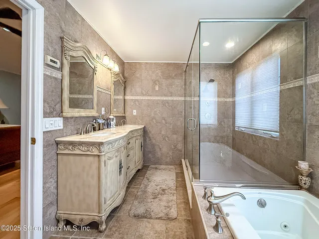 a bathroom with a tub sink and mirror
