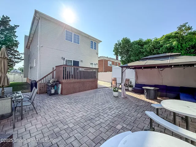 a view of backyard with furniture and a tub