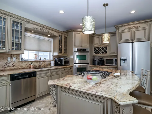 a kitchen with stainless steel appliances granite countertop a sink a stove and a refrigerator