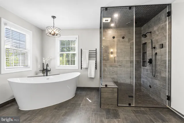 a spacious bathroom with double vanity a mirror a bathtub and shower