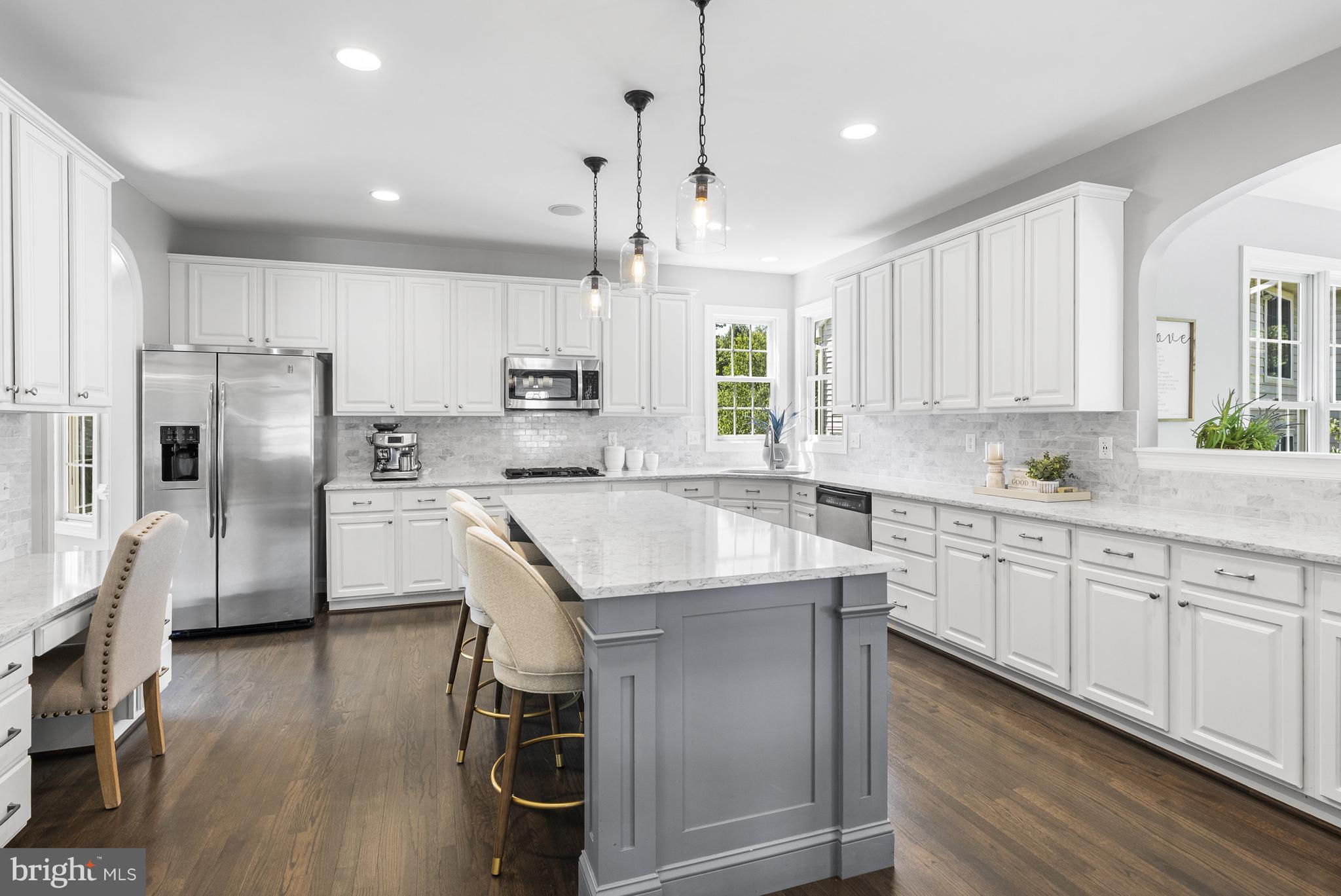 10205 Deep Skies Drive Laurel, MD 20723 - Photo 4 of 40 a kitchen with stainless steel appliances granite countertop a refrigerator a sink dishwasher a stove and white cabinets with wooden floor