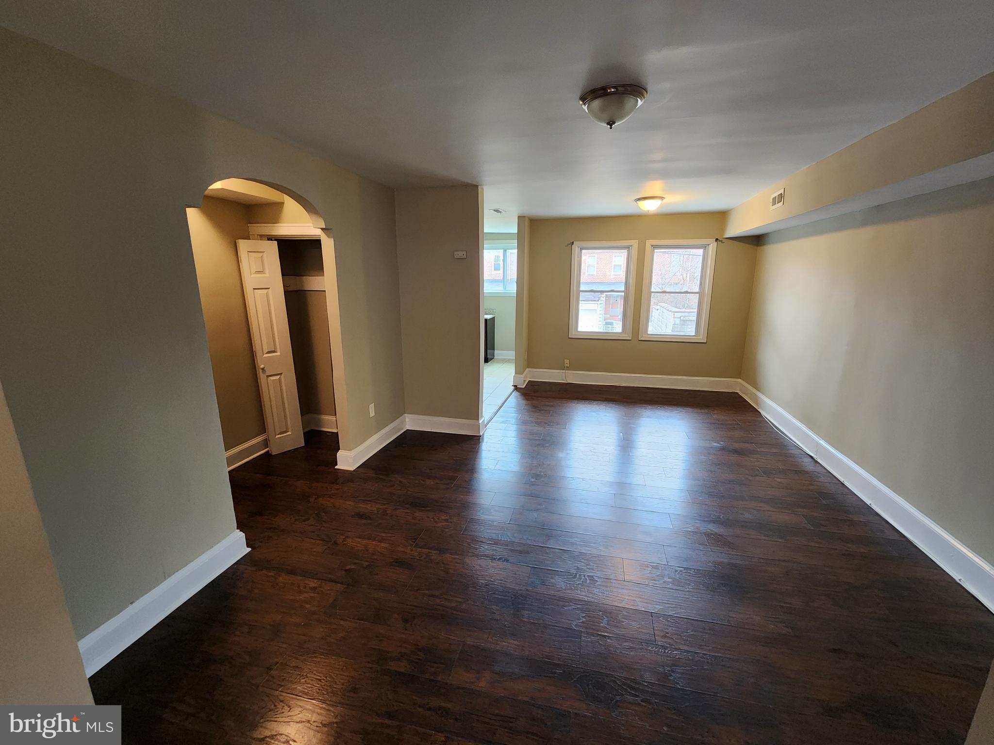 3316 Ramona Avenue Baltimore, MD 21213 - Photo 3 of 14 an empty room with wooden floor and windows