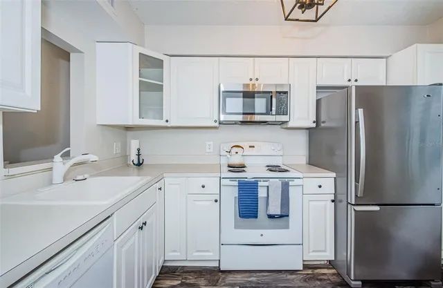 a kitchen with a refrigerator and a stove top oven